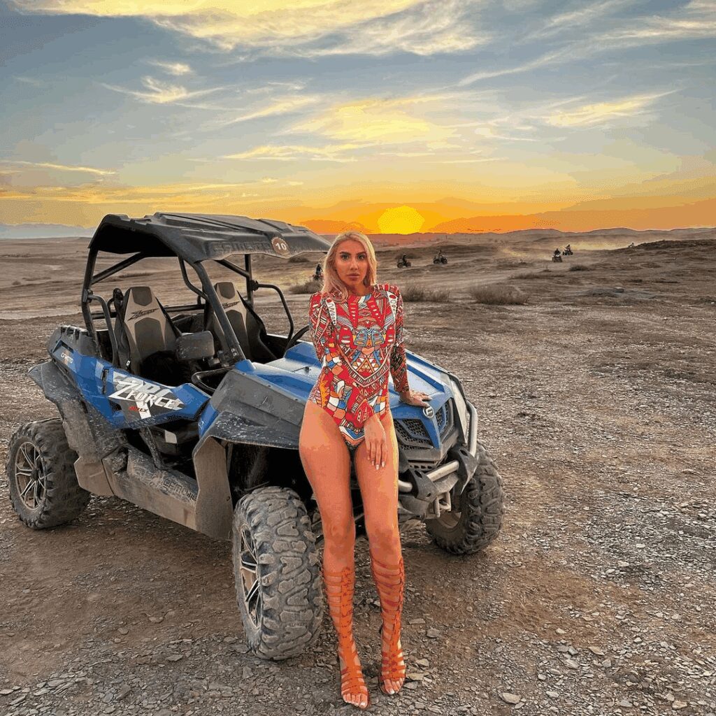 Woman posing beside buggy during sunset quad tour in Marrakech Agafay desert