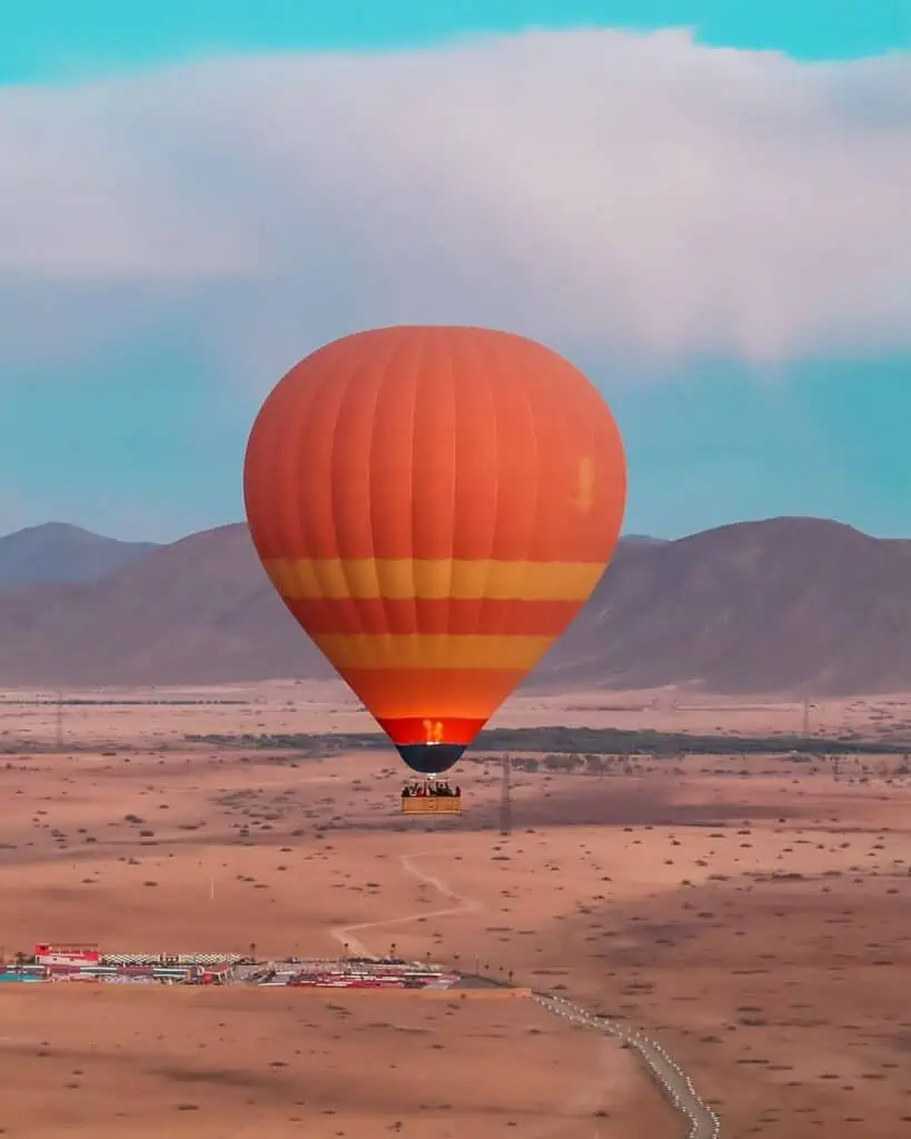 Red hot air balloon flying over Agafay desert Marrakech