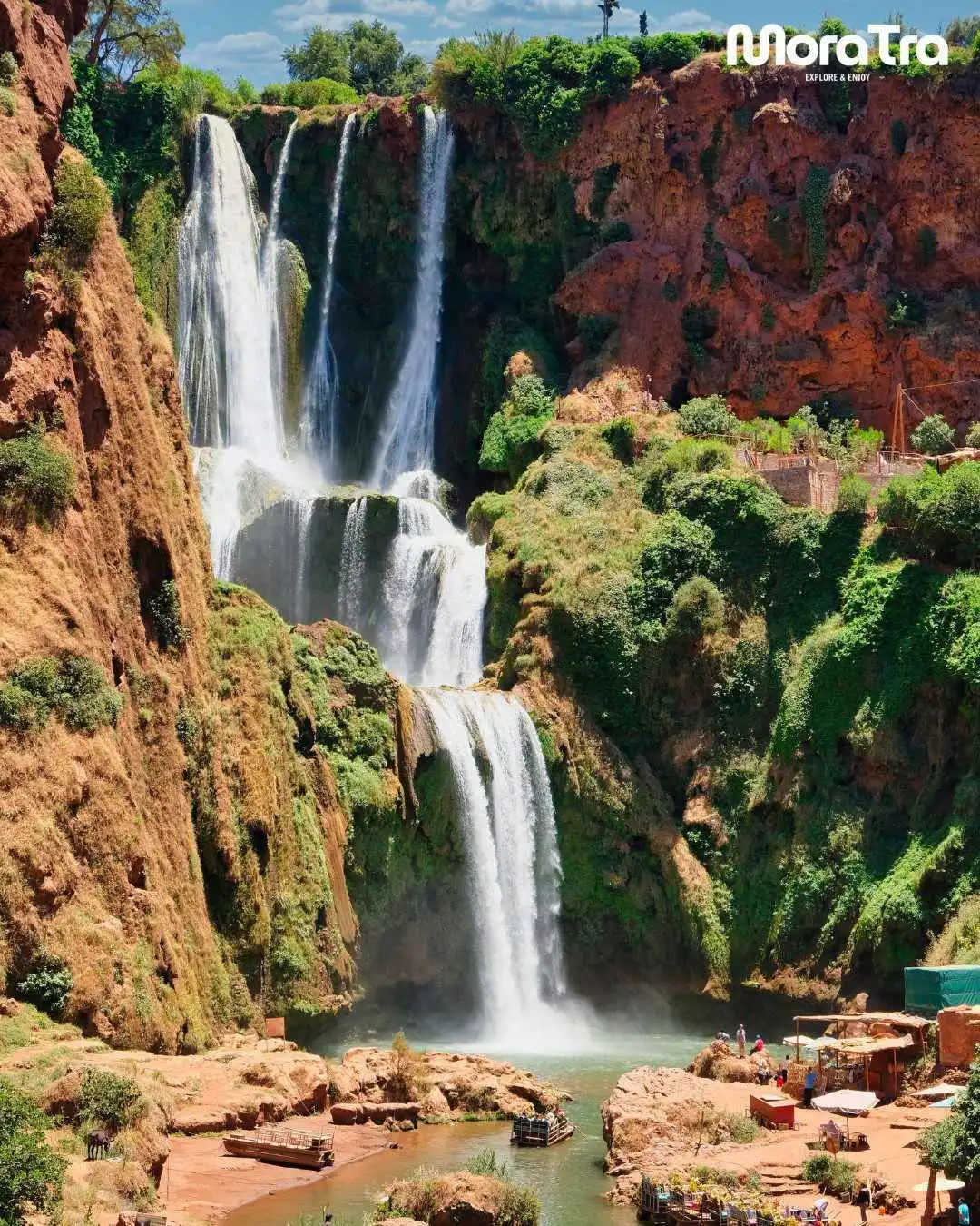 Beautiful view of Ouzoud Waterfalls surrounded by red cliffs and lush greenery during a Marrakech day trip