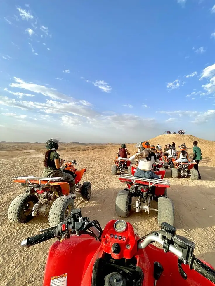 Group of quad bikes stopped in the Agafay Desert near Marrakech for a photo break during a quad biking tour