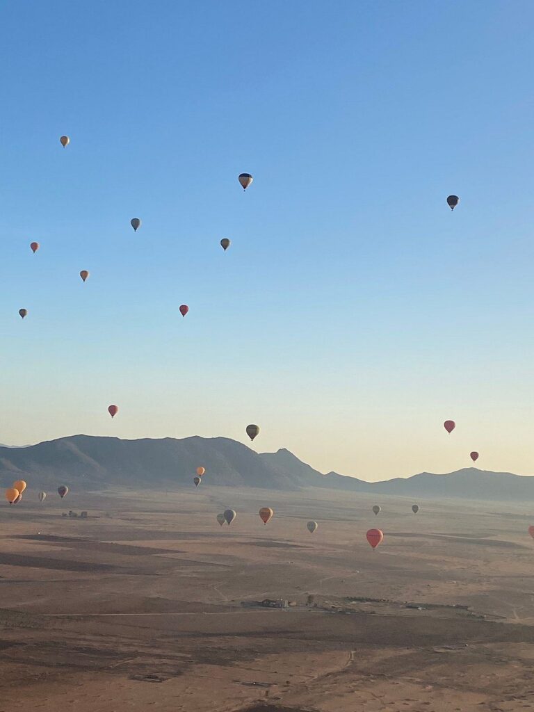 Hot-air balloons rising over the plains outside Marrakech at dawn
