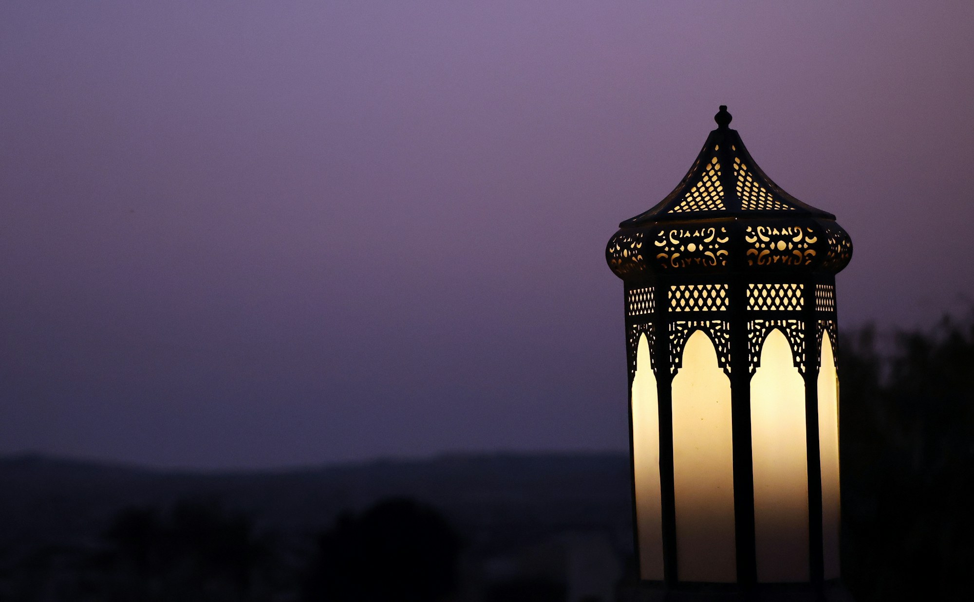 Lantern glowing in the Moroccan desert at dusk during Ramadan