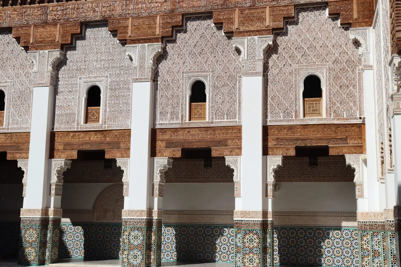Carved cedar, stucco and zellige around the courtyard of the Ben Youssef Madrasa in Marrakech
